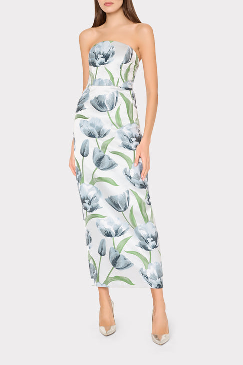 Woman wearing a strapless floral dress on a white background