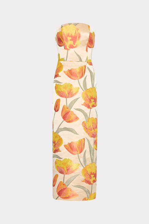A strapless maxi dress with a floral pattern featuring primarily yellow and orange tulips on a beige background.